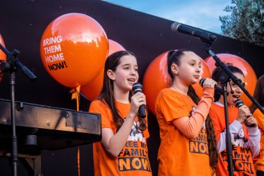 Tel Aviv, İsrail - 18 Ocak 2024 Genç kızlar, bugün 1 yaşına basan ve hala Hamas 'ın rehinesi olan Kfir' in en hüzünlü doğum günü münasebetiyle düzenlenen etkinlikte şarkı söyleyip katıldılar.