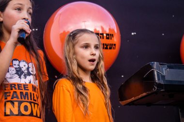 Tel Aviv, İsrail - 18 Ocak 2024 Genç kızlar, bugün 1 yaşına basan ve hala Hamas 'ın rehinesi olan Kfir' in en hüzünlü doğum günü münasebetiyle düzenlenen etkinlikte şarkı söyleyip katıldılar.