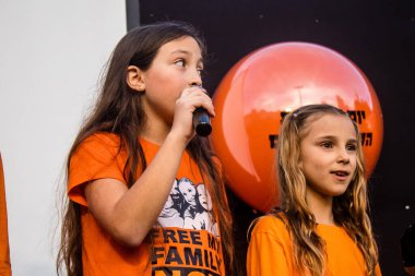 Tel Aviv, İsrail - 18 Ocak 2024 Genç kızlar, bugün 1 yaşına basan ve hala Hamas 'ın rehinesi olan Kfir' in en hüzünlü doğum günü münasebetiyle düzenlenen etkinlikte şarkı söyleyip katıldılar.