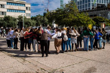 Tel Aviv, İsrail - 25 Ocak 2024 İsrailli gençler Tel Aviv 'deki Rehine Meydanı' nda hala Gazze 'de tutulan 100 rehinenin anısına şarkı söylüyorlar. İnsanlar düzenli olarak rehine ailelerini desteklemek için toplanır.