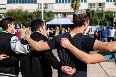 Tel Aviv, İsrail - 25 Ocak 2024 İsrailli gençler Tel Aviv 'deki Rehine Meydanı' nda hala Gazze 'de tutulan 100 rehinenin anısına şarkı söylüyorlar. İnsanlar düzenli olarak rehine ailelerini desteklemek için toplanır.