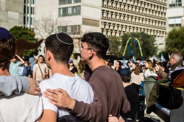 Tel Aviv, İsrail - 25 Ocak 2024 İsrailli gençler Tel Aviv 'deki Rehine Meydanı' nda hala Gazze 'de tutulan 100 rehinenin anısına şarkı söylüyorlar. İnsanlar düzenli olarak rehine ailelerini desteklemek için toplanır.