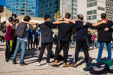 Tel Aviv, İsrail - 25 Ocak 2024 İsrailli gençler Tel Aviv 'deki Rehine Meydanı' nda hala Gazze 'de tutulan 100 rehinenin anısına şarkı söylüyorlar. İnsanlar düzenli olarak rehine ailelerini desteklemek için toplanır.