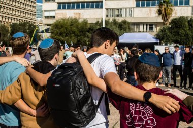 Tel Aviv, İsrail - 25 Ocak 2024 İsrailli gençler Tel Aviv 'deki Rehine Meydanı' nda hala Gazze 'de tutulan 100 rehinenin anısına şarkı söylüyorlar. İnsanlar düzenli olarak rehine ailelerini desteklemek için toplanır.