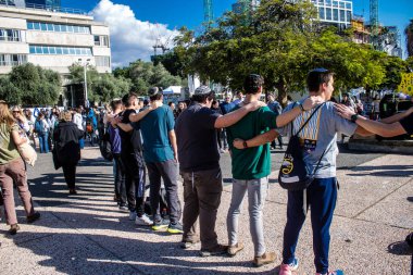 Tel Aviv, İsrail - 25 Ocak 2024 İsrailli gençler Tel Aviv 'deki Rehine Meydanı' nda hala Gazze 'de tutulan 100 rehinenin anısına şarkı söylüyorlar. İnsanlar düzenli olarak rehine ailelerini desteklemek için toplanır.