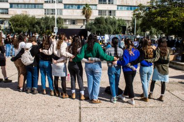 Tel Aviv, İsrail - 25 Ocak 2024 İsrailli gençler Tel Aviv 'deki Rehine Meydanı' nda hala Gazze 'de tutulan 100 rehinenin anısına şarkı söylüyorlar. İnsanlar düzenli olarak rehine ailelerini desteklemek için toplanır.