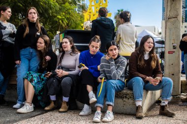 Tel Aviv, İsrail - 25 Ocak 2024 İsrailli gençler Tel Aviv 'deki Rehine Meydanı' nda hala Gazze 'de tutulan 100 rehinenin anısına şarkı söylüyorlar. İnsanlar düzenli olarak rehine ailelerini desteklemek için toplanır.