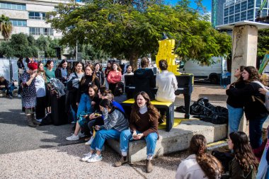 Tel Aviv, İsrail - 25 Ocak 2024 İsrailli gençler Tel Aviv 'deki Rehine Meydanı' nda hala Gazze 'de tutulan 100 rehinenin anısına şarkı söylüyorlar. İnsanlar düzenli olarak rehine ailelerini desteklemek için toplanır.