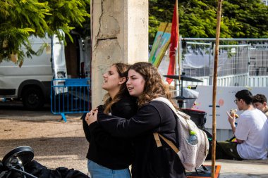Tel Aviv, İsrail - 25 Ocak 2024 İsrailli gençler Tel Aviv 'deki Rehine Meydanı' nda hala Gazze 'de tutulan 100 rehinenin anısına şarkı söylüyorlar. İnsanlar düzenli olarak rehine ailelerini desteklemek için toplanır.