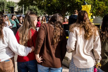Tel Aviv, İsrail - 25 Ocak 2024 İsrailli gençler Tel Aviv 'deki Rehine Meydanı' nda hala Gazze 'de tutulan 100 rehinenin anısına şarkı söylüyorlar. İnsanlar düzenli olarak rehine ailelerini desteklemek için toplanır.