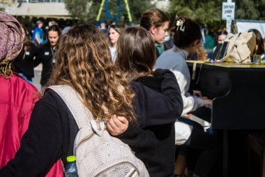 Tel Aviv, İsrail - 25 Ocak 2024 İsrailli gençler Tel Aviv 'deki Rehine Meydanı' nda hala Gazze 'de tutulan 100 rehinenin anısına şarkı söylüyorlar. İnsanlar düzenli olarak rehine ailelerini desteklemek için toplanır.