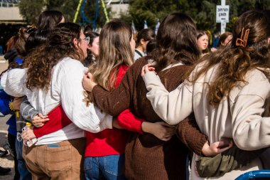 Tel Aviv, İsrail - 25 Ocak 2024 İsrailli gençler Tel Aviv 'deki Rehine Meydanı' nda hala Gazze 'de tutulan 100 rehinenin anısına şarkı söylüyorlar. İnsanlar düzenli olarak rehine ailelerini desteklemek için toplanır.
