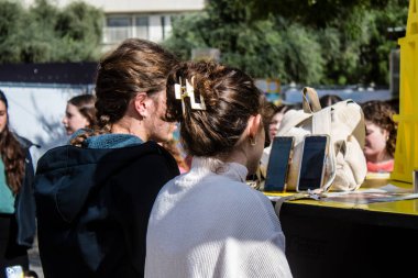 Tel Aviv, İsrail - 25 Ocak 2024 İsrailli gençler Tel Aviv 'deki Rehine Meydanı' nda hala Gazze 'de tutulan 100 rehinenin anısına şarkı söylüyorlar. İnsanlar düzenli olarak rehine ailelerini desteklemek için toplanır.