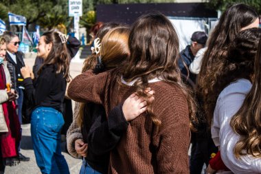 Tel Aviv, İsrail - 25 Ocak 2024 İsrailli gençler Tel Aviv 'deki Rehine Meydanı' nda hala Gazze 'de tutulan 100 rehinenin anısına şarkı söylüyorlar. İnsanlar düzenli olarak rehine ailelerini desteklemek için toplanır.