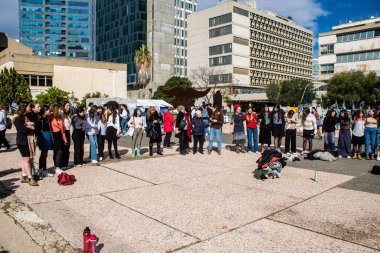 Tel Aviv, İsrail - 25 Ocak 2024 İsrailli gençler Tel Aviv 'deki Rehine Meydanı' nda hala Gazze 'de tutulan 100 rehinenin anısına şarkı söylüyorlar. İnsanlar düzenli olarak rehine ailelerini desteklemek için toplanır.