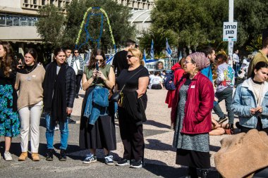 Tel Aviv, İsrail - 25 Ocak 2024 İsrailli gençler Tel Aviv 'deki Rehine Meydanı' nda hala Gazze 'de tutulan 100 rehinenin anısına şarkı söylüyorlar. İnsanlar düzenli olarak rehine ailelerini desteklemek için toplanır.