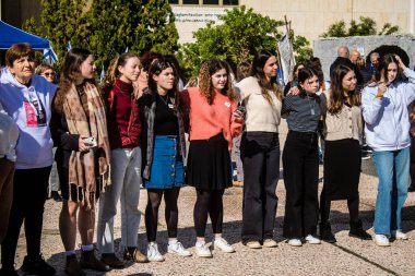 Tel Aviv, İsrail - 25 Ocak 2024 İsrailli gençler Tel Aviv 'deki Rehine Meydanı' nda hala Gazze 'de tutulan 100 rehinenin anısına şarkı söylüyorlar. İnsanlar düzenli olarak rehine ailelerini desteklemek için toplanır.