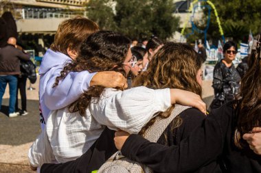 Tel Aviv, İsrail - 25 Ocak 2024 İsrailli gençler Tel Aviv 'deki Rehine Meydanı' nda hala Gazze 'de tutulan 100 rehinenin anısına şarkı söylüyorlar. İnsanlar düzenli olarak rehine ailelerini desteklemek için toplanır.