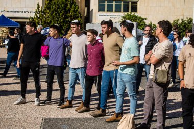 Tel Aviv, İsrail - 25 Ocak 2024 İsrailli gençler Tel Aviv 'deki Rehine Meydanı' nda hala Gazze 'de tutulan 100 rehinenin anısına şarkı söylüyorlar. İnsanlar düzenli olarak rehine ailelerini desteklemek için toplanır.