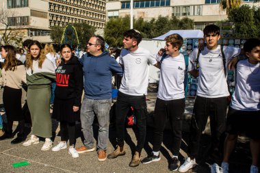 Tel Aviv, İsrail - 25 Ocak 2024 İsrailli gençler Tel Aviv 'deki Rehine Meydanı' nda hala Gazze 'de tutulan 100 rehinenin anısına şarkı söylüyorlar. İnsanlar düzenli olarak rehine ailelerini desteklemek için toplanır.