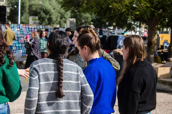 Tel Aviv, İsrail - 25 Ocak 2024 İsrailli gençler Tel Aviv 'deki Rehine Meydanı' nda hala Gazze 'de tutulan 100 rehinenin anısına şarkı söylüyorlar. İnsanlar düzenli olarak rehine ailelerini desteklemek için toplanır.