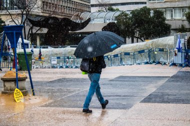 Tel Aviv, İsrail, 18 Şubat 2024 İsrail 'in sembolik ve simgesel şehri Tel Aviv sokaklarında şemsiyeyle yürüyen insanlar
