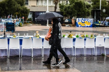 Tel Aviv, İsrail, 18 Şubat 2024 İsrail 'in sembolik ve simgesel şehri Tel Aviv sokaklarında şemsiyeyle yürüyen insanlar