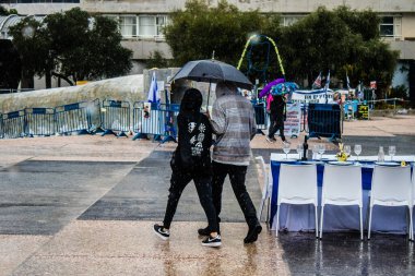 Tel Aviv, İsrail, 18 Şubat 2024 İsrail 'in sembolik ve simgesel şehri Tel Aviv sokaklarında şemsiyeyle yürüyen insanlar