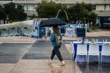 Tel Aviv, İsrail, 18 Şubat 2024 İsrail 'in sembolik ve simgesel şehri Tel Aviv sokaklarında şemsiyeyle yürüyen insanlar