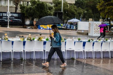 Tel Aviv, İsrail, 18 Şubat 2024 İsrail 'in sembolik ve simgesel şehri Tel Aviv sokaklarında şemsiyeyle yürüyen insanlar