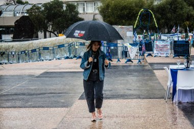 Tel Aviv, İsrail, 18 Şubat 2024 İsrail 'in sembolik ve simgesel şehri Tel Aviv sokaklarında şemsiyeyle yürüyen insanlar