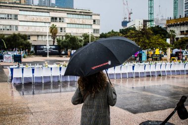 Tel Aviv, İsrail, 18 Şubat 2024 İsrail 'in sembolik ve simgesel şehri Tel Aviv sokaklarında şemsiyeyle yürüyen insanlar