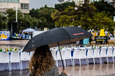 Tel Aviv, İsrail, 18 Şubat 2024 İsrail 'in sembolik ve simgesel şehri Tel Aviv sokaklarında şemsiyeyle yürüyen insanlar