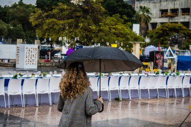 Tel Aviv, İsrail, 18 Şubat 2024 İsrail 'in sembolik ve simgesel şehri Tel Aviv sokaklarında şemsiyeyle yürüyen insanlar