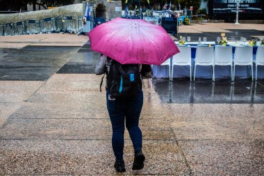 Tel Aviv, İsrail, 18 Şubat 2024 İsrail 'in sembolik ve simgesel şehri Tel Aviv sokaklarında şemsiyeyle yürüyen insanlar