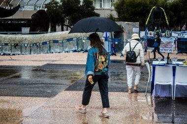 Tel Aviv, İsrail, 18 Şubat 2024 İsrail 'in sembolik ve simgesel şehri Tel Aviv sokaklarında şemsiyeyle yürüyen insanlar