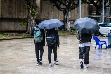 Tel Aviv, İsrail, 18 Şubat 2024 İsrail 'in sembolik ve simgesel şehri Tel Aviv sokaklarında şemsiyeyle yürüyen insanlar