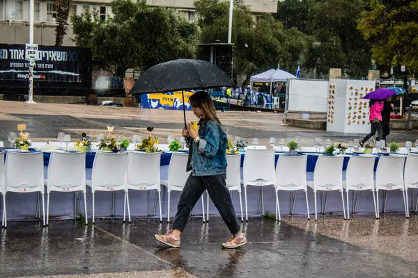 Tel Aviv, İsrail, 18 Şubat 2024 İsrail 'in sembolik ve simgesel şehri Tel Aviv sokaklarında şemsiyeyle yürüyen insanlar