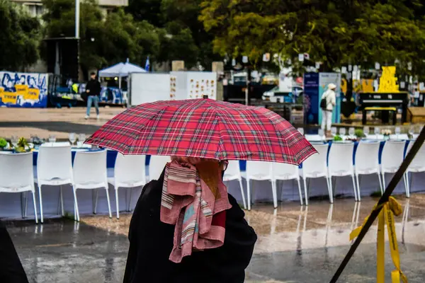 Tel Aviv, İsrail, 18 Şubat 2024 İsrail 'in sembolik ve simgesel şehri Tel Aviv sokaklarında şemsiyeyle yürüyen insanlar