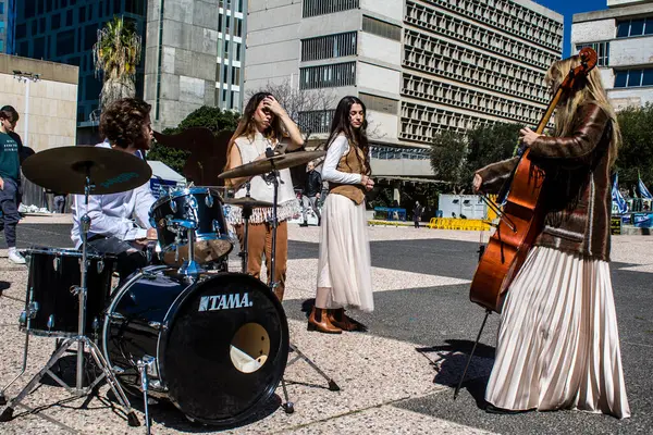 Tel Aviv, İsrail, 21 Şubat 2024 Rehine Meydanı 'ndaki Tel Aviv Sanat Müzesi' nin önünde çalan müzisyenler, insanların Hamas tarafından kaçırılanların ve tutsak edilenlerin anısına toplandıkları bir yer.