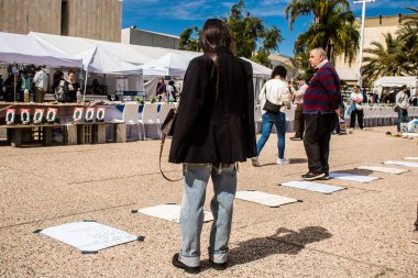 Tel Aviv, İsrail, 1 Mart 2024 İsrailliler, bugün Rehineler Meydanı olarak bilinen yerde Hamas tarafından rehin tutulan veya öldürülen çocukları resmeden bebeklere bakıyorlar.