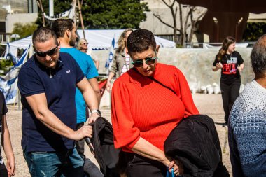 Tel Aviv, İsrail, 1 Mart 2024 İsrailliler, bugün Rehineler Meydanı olarak bilinen yerde Hamas tarafından rehin tutulan veya öldürülen çocukları resmeden bebeklere bakıyorlar.
