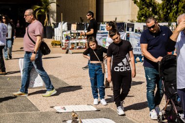 Tel Aviv, İsrail, 1 Mart 2024 İsrailliler, bugün Rehineler Meydanı olarak bilinen yerde Hamas tarafından rehin tutulan veya öldürülen çocukları resmeden bebeklere bakıyorlar.