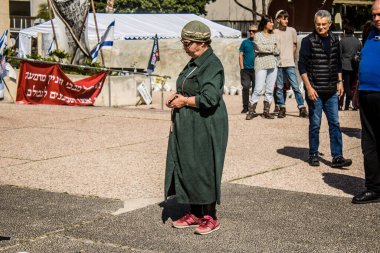 Tel Aviv, İsrail, 1 Mart 2024 İsrailliler, bugün Rehineler Meydanı olarak bilinen yerde Hamas tarafından rehin tutulan veya öldürülen çocukları resmeden bebeklere bakıyorlar.