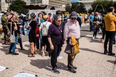 Tel Aviv, İsrail, 1 Mart 2024 İsrailliler, bugün Rehineler Meydanı olarak bilinen yerde Hamas tarafından rehin tutulan veya öldürülen çocukları resmeden bebeklere bakıyorlar.