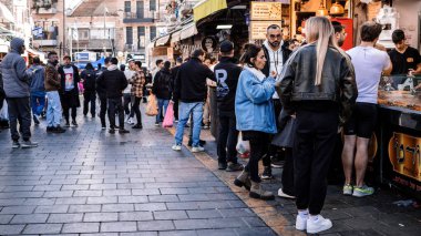 Kudüs, İsrail - 22 Aralık 2023 Mahane Yehuda Pazarı 'nda alışveriş yapan insanlar, genellikle 