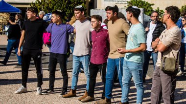 Tel Aviv, İsrail - 25 Ocak 2024 İsrailli gençler Tel Aviv 'deki Rehine Meydanı' nda hala Gazze 'de tutulan 100 rehinenin anısına şarkı söylüyorlar. İnsanlar düzenli olarak rehine ailelerini desteklemek için toplanır.