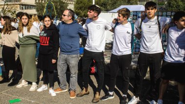 Tel Aviv, İsrail - 25 Ocak 2024 İsrailli gençler Tel Aviv 'deki Rehine Meydanı' nda hala Gazze 'de tutulan 100 rehinenin anısına şarkı söylüyorlar. İnsanlar düzenli olarak rehine ailelerini desteklemek için toplanır.