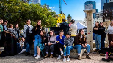 Tel Aviv, İsrail - 25 Ocak 2024 İsrailli gençler Tel Aviv 'deki Rehine Meydanı' nda hala Gazze 'de tutulan 100 rehinenin anısına şarkı söylüyorlar. İnsanlar düzenli olarak rehine ailelerini desteklemek için toplanır.