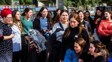 Tel Aviv, İsrail - 25 Ocak 2024 İsrailli gençler Tel Aviv 'deki Rehine Meydanı' nda hala Gazze 'de tutulan 100 rehinenin anısına şarkı söylüyorlar. İnsanlar düzenli olarak rehine ailelerini desteklemek için toplanır.